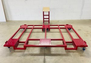 A red painted bespoke transportation unit to move specific works within the manufacturing and assembly process. Made Using Box Section and sheet metal, and finished with Powder Coating in Red.