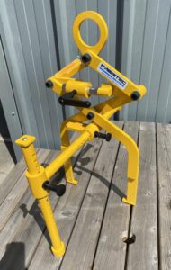 A yellow powder coated lifting device for a car assembly line.